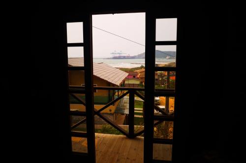 an open door to a balcony with a view at Chalé com Piscina Aquecida - Vista Panorâmica da Praia, a 200m do Mar, Sala de Jogos, Academia e Churrasqueira in Imbituba