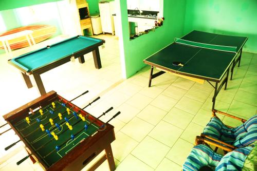 a living room with a ping pong table and a ping pongetitive at Chalé com Piscina Aquecida - Vista Panorâmica da Praia, a 200m do Mar, Sala de Jogos, Academia e Churrasqueira in Imbituba