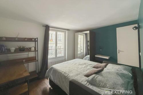 une chambre avec un lit avec un mur bleu dans l'établissement Flexliving - Studio - Martyrs, à Paris