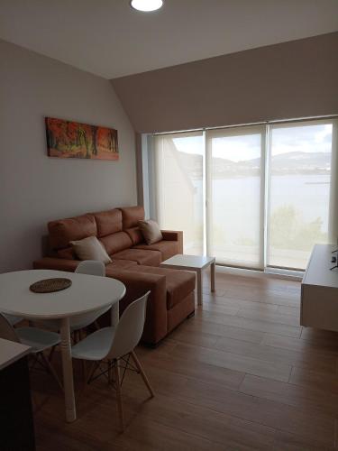 a living room with a couch and a table at Apartamentos Mar y Playa in Moaña