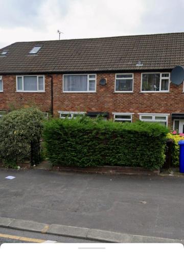 a brick house with a hedge in front of it at Komegloba Exquisite room in Manchester