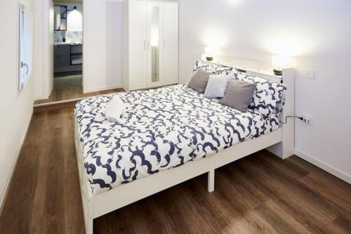 a white bed with a black and white comforter at Loft dal design raffinato a Vigonovo in Fontanafredda