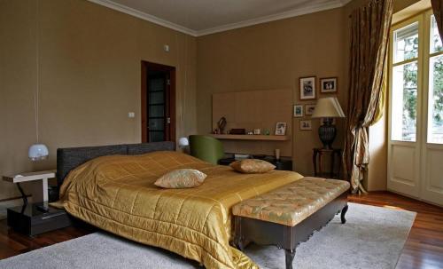 ein Schlafzimmer mit einem großen Bett mit einer goldenen Decke in der Unterkunft Kalliope House in Akrotiri