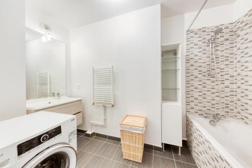 a washing machine in a bathroom with a tub and a sink at T2 Jardin cosy et lumineux proche Paris in Bezons