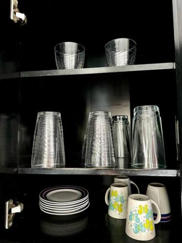 a shelf with pots and pans and cups and plates at Casa Solares descanso ideal in Atlixco