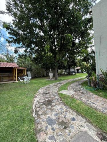 a garden with a tree and a stone walkway at Casa Solares descanso ideal in Atlixco