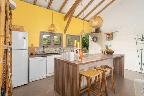 a kitchen with yellow walls and a white refrigerator at Villa moderne avec piscine à Le Vauclin in Le Vauclin