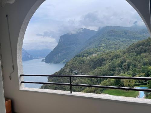 a window with a view of a lake and mountains at Appartamenti Lago di Como in Valbrona