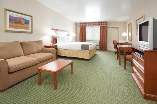 a hotel room with a bed and a couch at Holiday Inn Express Hotel & Suites Gunnison by IHG in Gunnison