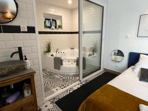 a bathroom with a tub and a bed and a shower at La Clé des Champs - Studio PiscineSPA-Sauna au jardin tropical idyllique et bucolique in Jouarre