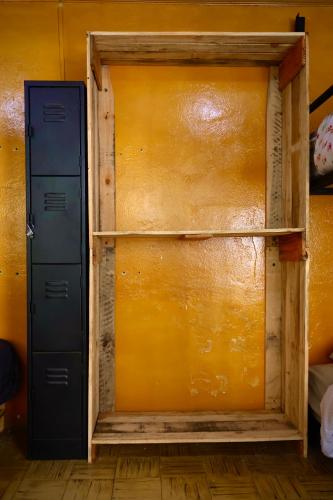 a room with a yellow wall with two shelves at Casa I`X in Quetzaltenango