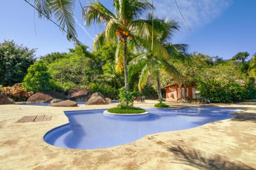 a palm tree sitting in the middle of a beach at Camping & Cabanas Ilhabela in Ilhabela