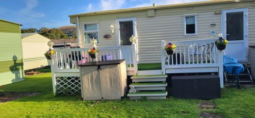 a tiny house with a porch and a fence at Cairnryan Heights home from home in Cairnryan