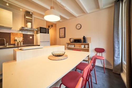 a kitchen with a table and red chairs at Appartement rénové au pied des pistes in La Plagne