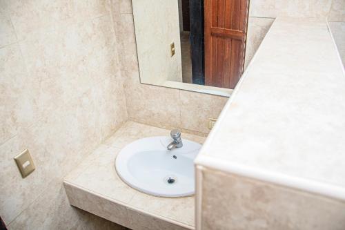 a bathroom with a sink and a mirror at Hotel Espor CA in Barinas