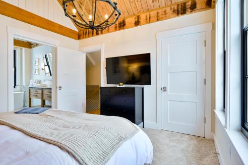 a bedroom with a bed and a flat screen tv at Academy Place | Bluebell in Crested Butte