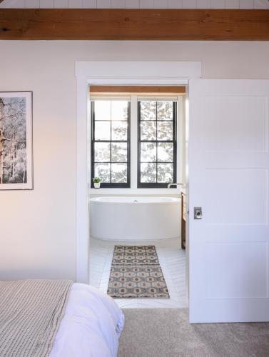 a bedroom with a bath tub and a window at Academy Place | Bluebell in Crested Butte