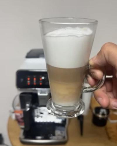 a person is holding a glass with a drink at Vila Aspen - Mountain View Apartments in Delčevo