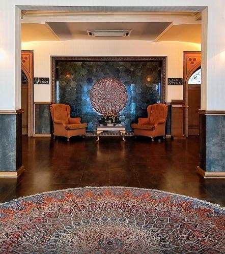 a room with two chairs and a table and a wall at Anemon Bursa Gönlüferah Termal&Spa Otel in Bursa