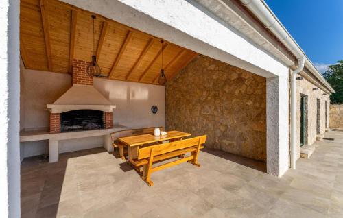 a patio with a wooden table and a fireplace at 4 Bedroom Cozy Home In Krusevo in Kruševo