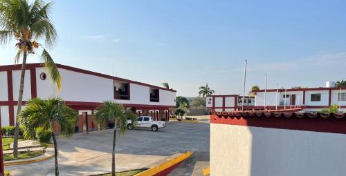 a parking lot in front of a red and white building at Hotel Espor CA in Barinas