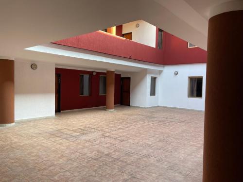 a large empty room with red and white walls at Hotel Espor CA in Barinas