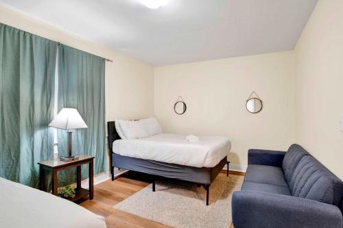 un soggiorno con un letto e un divano di Near Downtown and Cornerstone - Southern Sunshine a Mobile