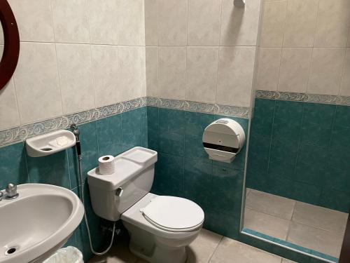 a bathroom with a toilet and a sink at Hotel Espor CA in Barinas