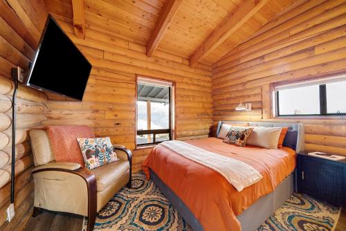 a bedroom with a bed and a tv in a log cabin at Elevation 40 Zion in Apple Valley