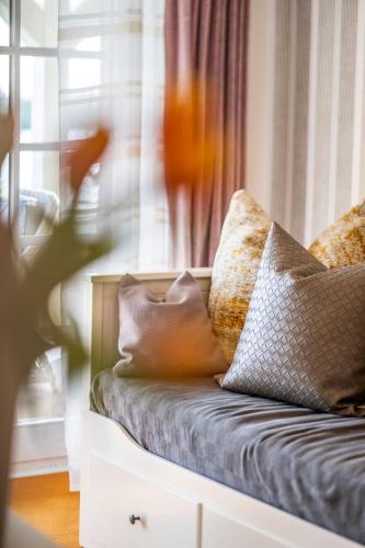 a couch with pillows sitting in front of a window at Seehotel Lichtenberg in Lichtenberg