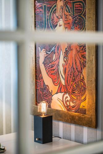 a painting of a woman on a wall with a candle at Seehotel Lichtenberg in Lichtenberg