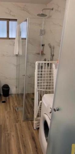 a bathroom with a shower and a crib in it at Kasa orlev in Herzelia 