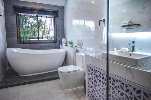 a bathroom with a tub and a toilet and a sink at Baan Santhiya Private Pool Villas - Free Tuk-Tuk Service to the Beach! in Ao Nang Beach