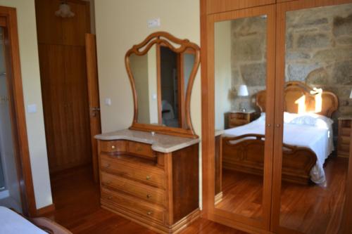 a bedroom with a wooden dresser and a mirror at Villa Rio in Tangil