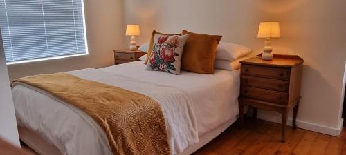 una camera da letto con un letto con due comodini e due lampade di 34onfifth a Port Elizabeth