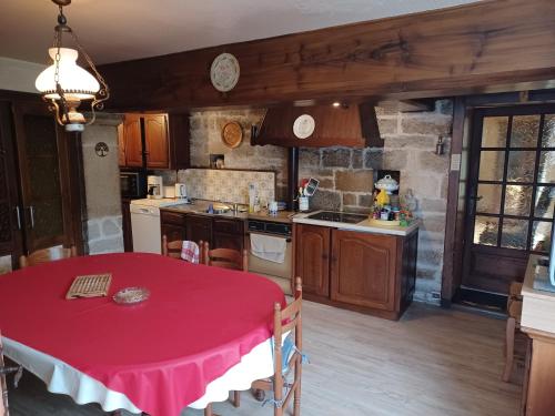 une cuisine avec une table et un chiffon rouge dans l'établissement Ferme comtoise de charme, à Goux-les-Usiers