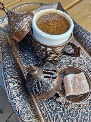 a cup of coffee and a spoon on a plate at Grand Chamois Hotel & Spa in Mavrovo