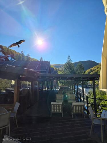 a bird flying over a patio with tables and chairs at Grand Chamois Hotel & Spa in Mavrovo