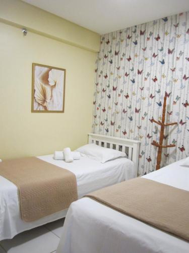 a hotel room with two beds and a curtain at Residence 207 Cabo Branco in João Pessoa
