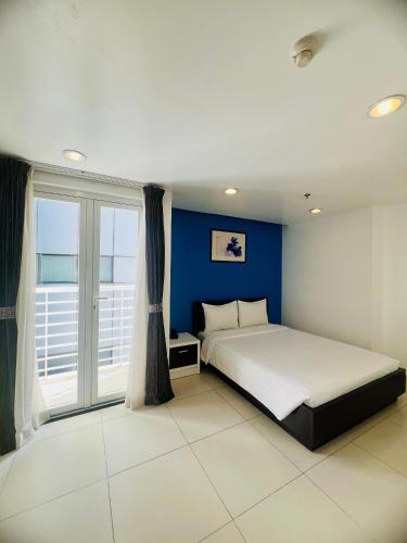 a bedroom with a bed and a blue wall at Minh Khang Hotel in Ho Chi Minh City