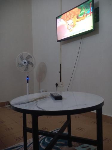 ムトワッパにあるStonehaven Fortune Apartments Mtwapaのテレビ、ファンが備わる客室です。