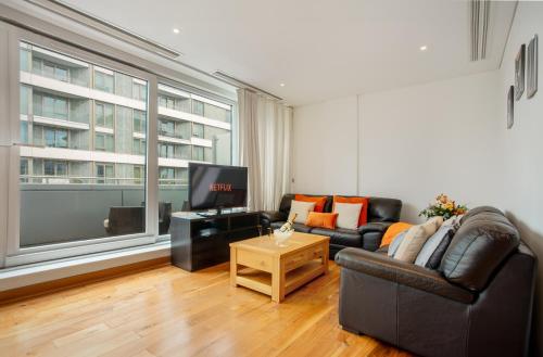a living room with a couch and a tv at Contemporary Penthouse in Battersea Power Station in London