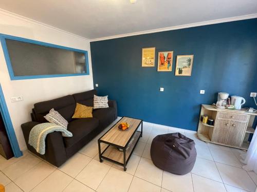 un salon avec un canapé noir et une table dans l'établissement Agréable chambre d'hôte à 50M de la mer, à Cannes