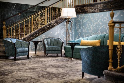 a living room with a couch and two chairs at Amway Grand Plaza Hotel, Curio Collection by Hilton in Grand Rapids