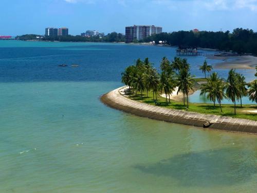 a beach with palm trees in the water at PD Infront Seaview in Port Dickson
