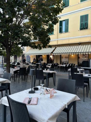 a restaurant with tables and chairs and a building at Albergo Florida Taggia in Taggia