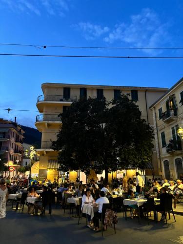 a group of people sitting at tables in front of a building at Albergo Florida Taggia in Taggia