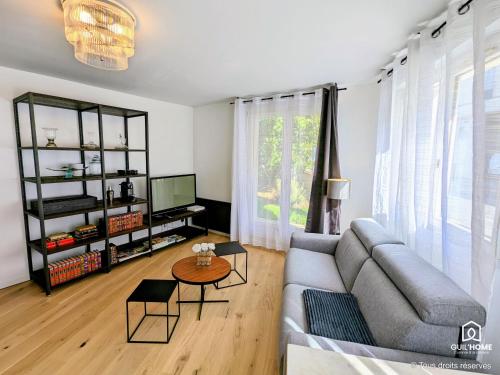 un salon avec un canapé et une table dans l'établissement Les Magnolias - Calme - Confort - Parking - Tram, à Orléans