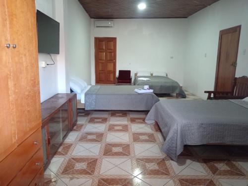 a room with two beds and a tv and a room with two beds at Alojamiento CASA LUNA in Iquitos