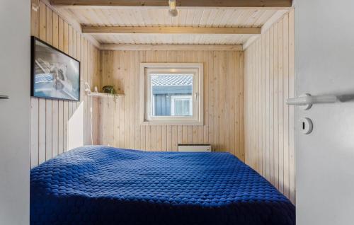 a bedroom with a blue bed with a window at 4 Bedroom Lovely Home In Sæby in Sæby